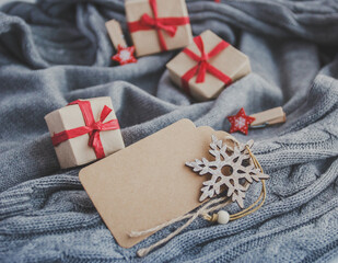Cozy winter composition with Christmas gift boxes and New Year decorations. Blank label and snowflake close up.
