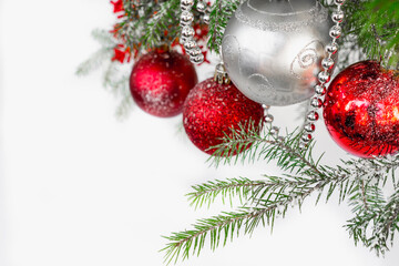 White and red balls on a fir branch as a traditional background for congratulations on Merry Christmas and Happy New Year
