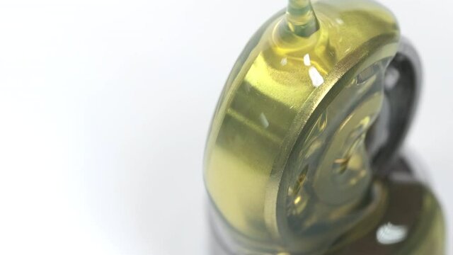 Closed up macro, Pouring yellow oil into ball bearing isolated on white backgroud with copy space. Oil help to protect wear and rust. Reduce friction. Engineering, service and industrial concept