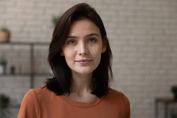 Head shot close up portrait of beautiful millennial 20s woman posing indoors, confident young brunette lady looking at camera, social network or dating application profile photo, youth generation. - obrazy, fototapety, plakaty