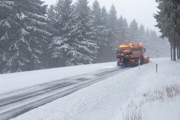 snow plow cleaning winter forest road, rear view