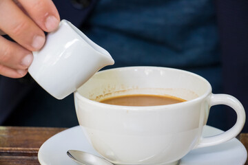 Pour syrup into hot americano coffee