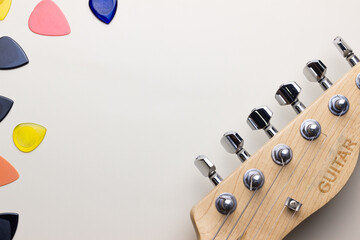 Electric guitar headstock and picks on table background with copy space
