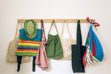 Reusable cloth bags hang in a row. Eco-friendly lifestyle and store shopping.