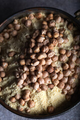 Chickpea flour and chickpea kernels in the old metal bowl.