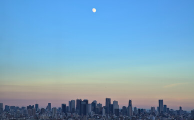 Panoramic view of the Shinjuku skyline in the early evening with the moon visible above
