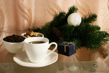 A cup of coffee on the table against the background of New Year's decor. Cup of coffee with Christmas decor on the table.