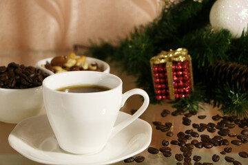 A cup of coffee on the table against the background of New Year's decor. Cup of coffee with Christmas decor on the table.