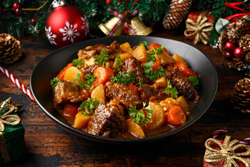 Christmas Beef Stew with decoration, gifts, green tree branch on wooden rustic table