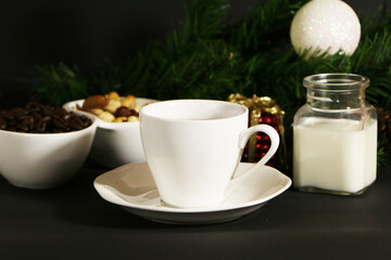 A cup of coffee on the table against the background of New Year's decor. Cup of coffee with Christmas decor on the table.