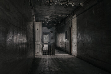 Dark gloomy corridor in an old abandoned building. Dirty wooden doors. Cracked on the walls. A...