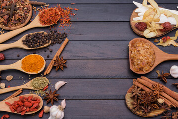 Spoon spices chili garlic salt pepper kosher on a dark wooden table. Top view with copy area