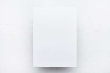 A sheet of paper lies top view on a wooden table with copy space