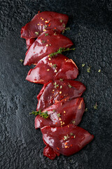 pigeon breast fillets ready to cook with seasoning mix on wooden board