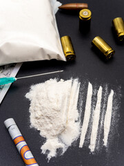 syringe hundred dollars bills cocaine heroine and pistol cartridges drug addiction social issues...