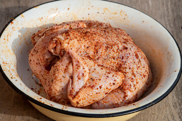 a whole chicken carcass in spices, raw and ready to cook