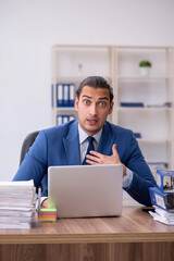 Fototapeta premium Young male employee unhappy with excessive work