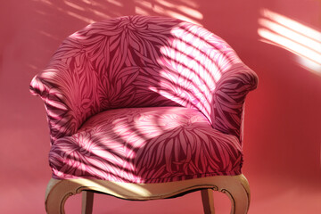 Pink comfortable vintage chair on pink background