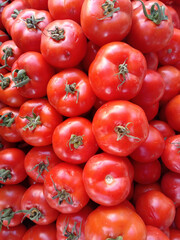 Fresh red organic tomatoes on grocery shelf.