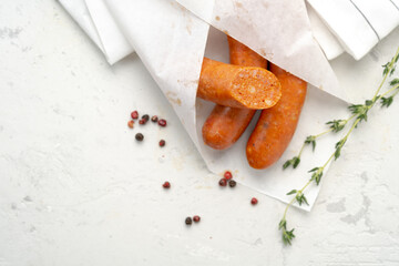 Traditional Spanish Chorizo sausages wrapped in paper with pepper and herbs, top view and copy space