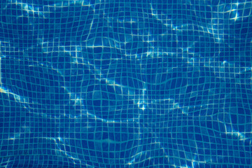 Small blue tiles in the pool. The bottom of the pool is visible through the clear water....