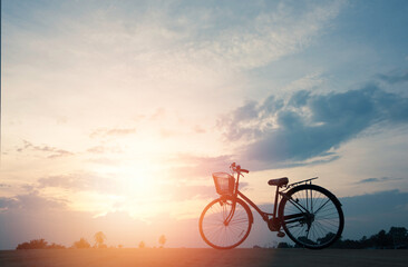 Fototapeta na wymiar silhouette of bicycle with beautiful cloudscape and sunlight.