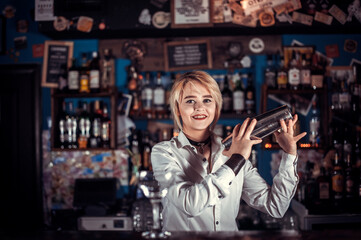 Experienced girl barman demonstrates the process of making a cocktail