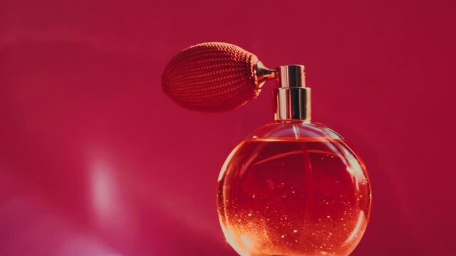 Vintage perfume bottle and shining light flares on red background, glamorous fragrance scent as luxury perfumery product for cosmetic and beauty brand, stock footage