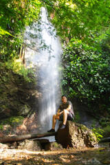 Fototapeta na wymiar Hombre en una cascada de agua natural en la selva