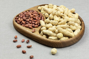 peanuts and peanuts in shell in a wooden bowl