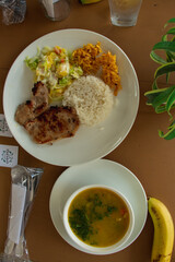 Plato de comida con sopa, arroz, carne y ensalada