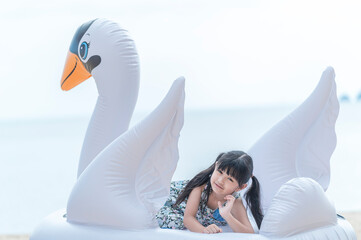 Happy smiling girl lying on fancy swimming ring, summer vacation and relax concept