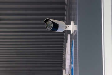 Security CCTV camera surveillance system outdoor of house. A blurred night city scape background. Modern CCTV camera on a wall. Equipment system service for safety life or asset.