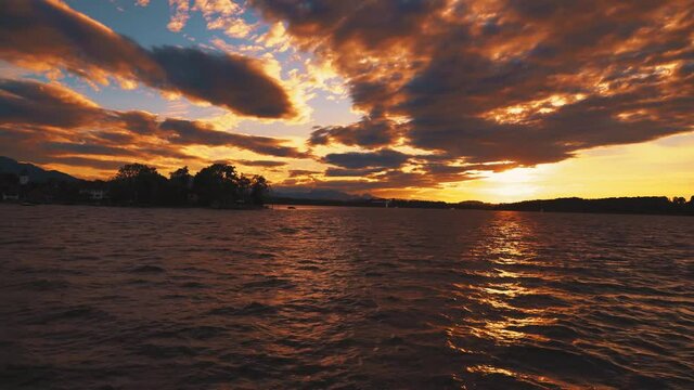 Boat ride on the historic steam ship Ludwig Fessler, built in 1927, across the Chiemsee lake in Bavaria, home to King Ludwig II of Bavaria's Versaille replica castle on an island by sunset. 4K UHD