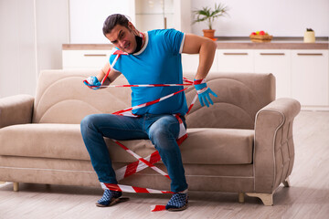 Roped young man being unhappy at home in quarantine concept