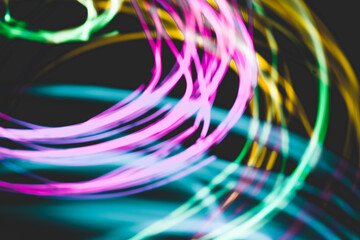 Abstract modern digital background. Pink, green, cyan, and yellow light circle motion in darkness