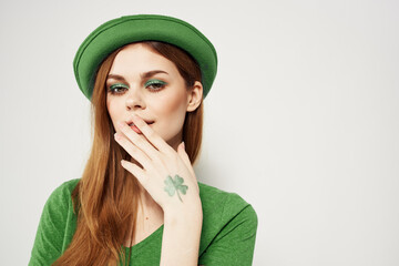 happy woman in green clothes in st patricks day shamrock hat makeup model