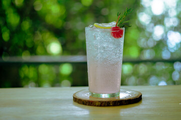 Sparkling soda mix with lychee juice decoration with rosemary, cherries and slice lemon