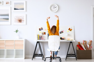 Unrecognizable designer stretching arms during work.