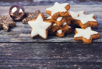 christmas background for greeting cards with copy space, cinnamon stars beside a christmas ball on wooden background