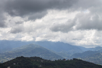 Mountain landscape against the background of black and white clouds. The view from the top.