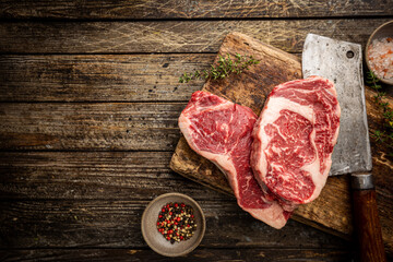 Variety of Fresh Raw Black Angus Prime Meat Steaks New York, Ribeye and seasoning on wooden background, top view