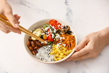 Woman eating rice salad with vegetables
