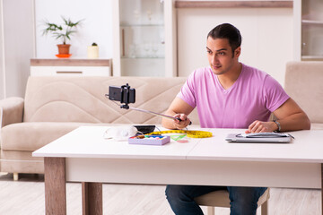 Young male tailor recording video for his blog during pandemic
