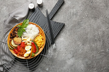 Plate of delicious rice salad with vegetables on dark background
