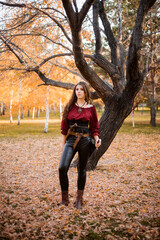 Attractive woman in a Spanish shirt and leather pants with a saber and a pistol on a belt posing...
