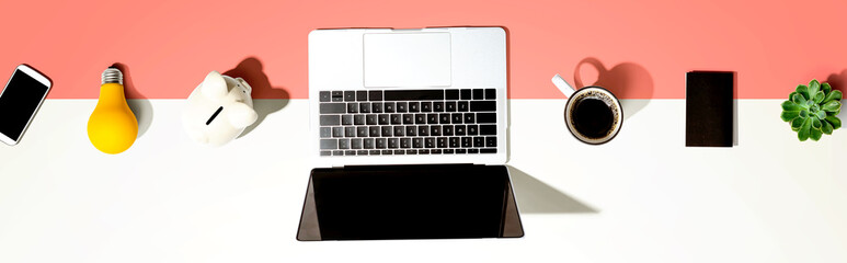 Laptop computer with a piggy bank and office objects