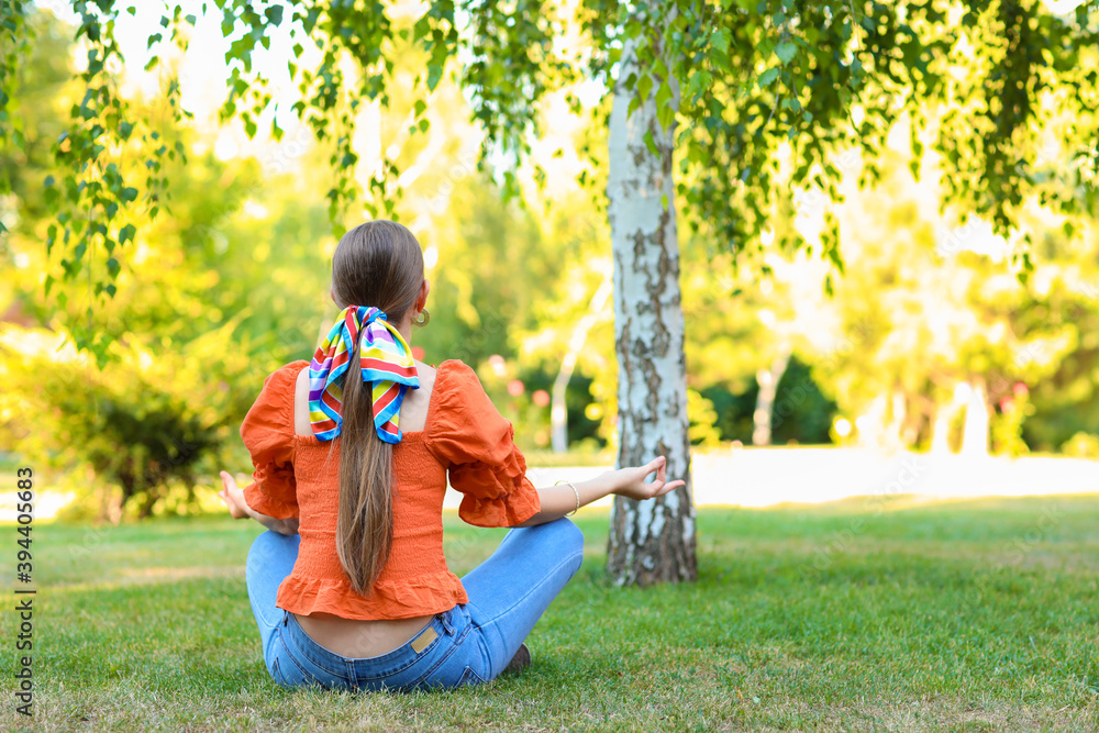 Sticker Beautiful young woman meditating in park