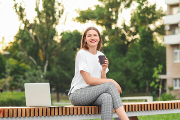 Beautiful young businesswoman relaxing in park