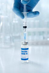 Male doctor or scientist hand wears medical glove holding syringe taking covid 19 corona virus...
